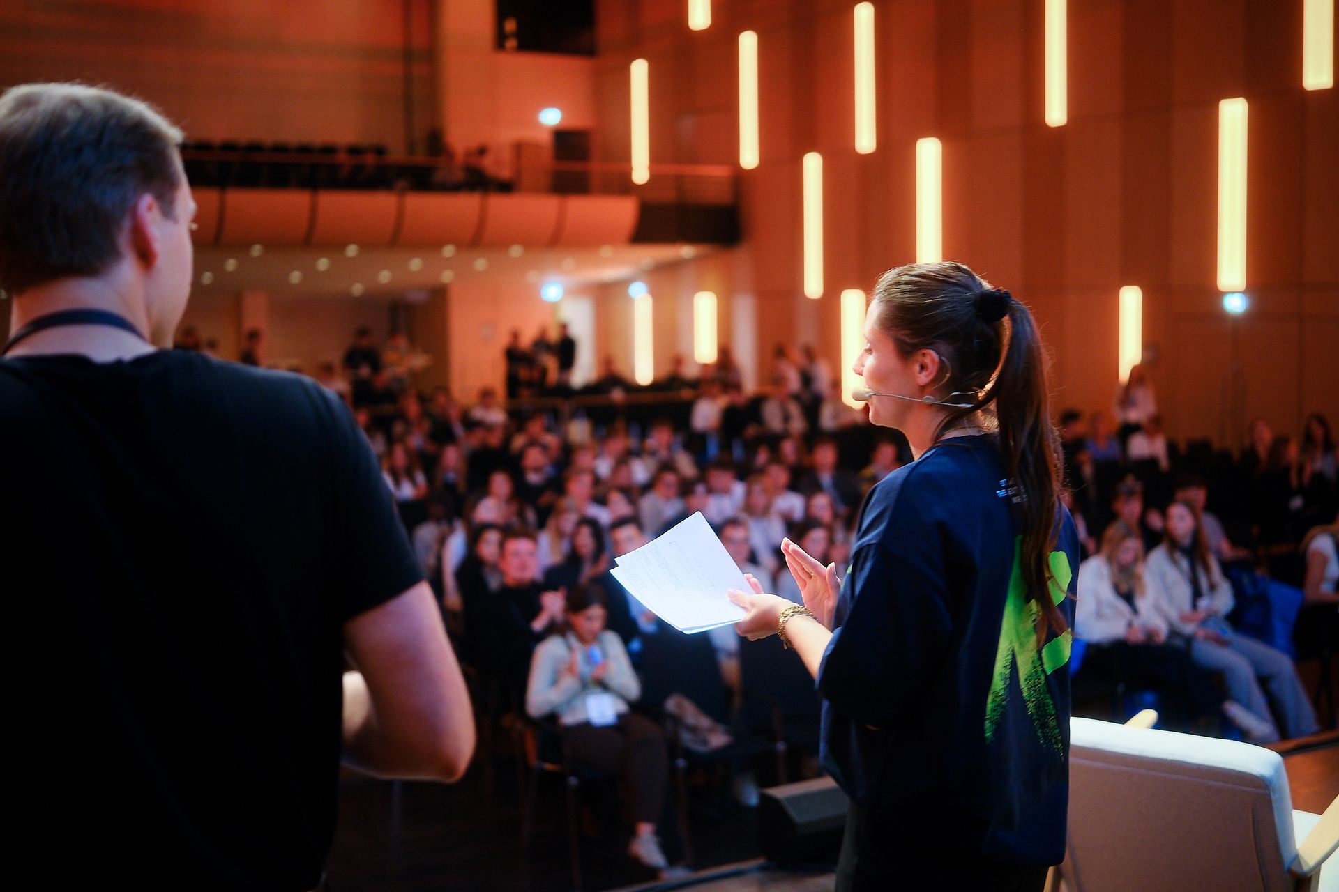 Host and CMO Rena Ronge speaks on stage in front of an audience at a startup conference