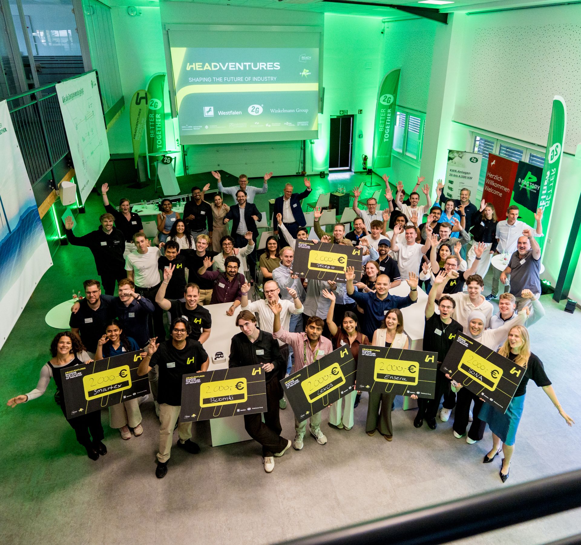 Group of startup founders celebrating with €2,000 prize checks at the HeadVentures R-Factory startup event